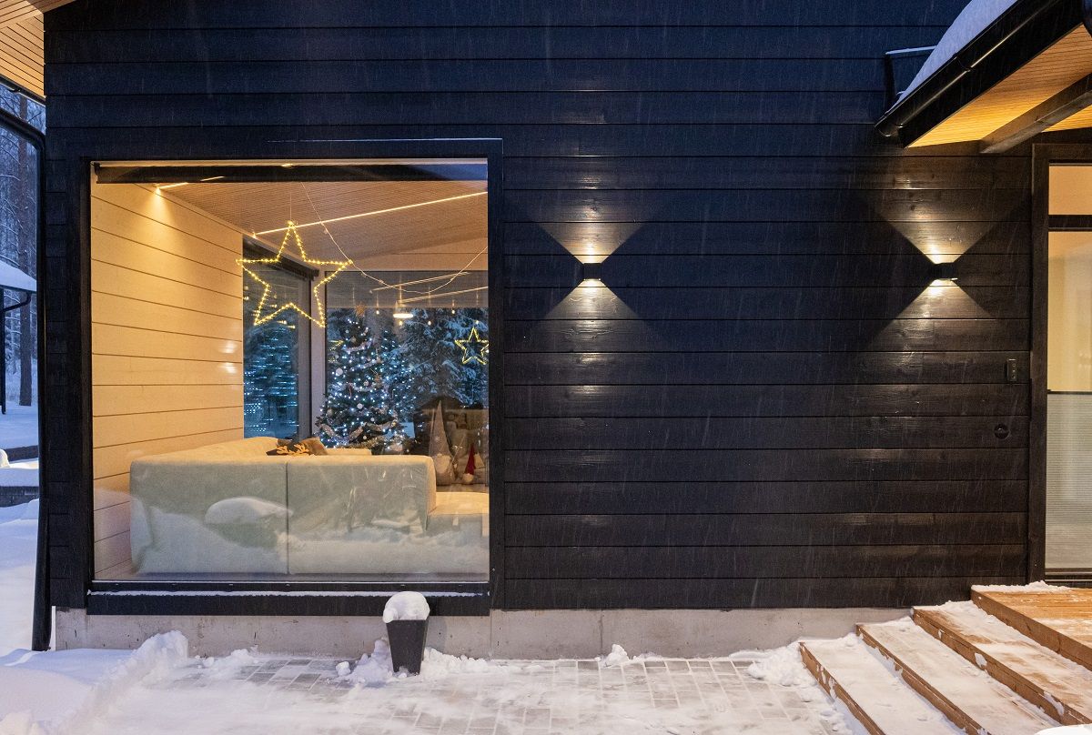 Su una parete esterna, un'applique Funk nera aggiunge un bellissimo effetto fotografico e la luce stessa si fonde con la tonalità della parete